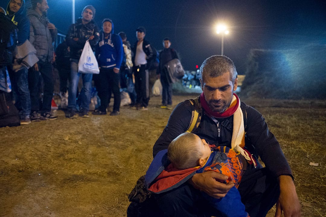 2015年10月7日,克罗地亚,一名难民抱着其两岁的儿子。摄:Ashley Gilbertson / VII Photo for UNICEF