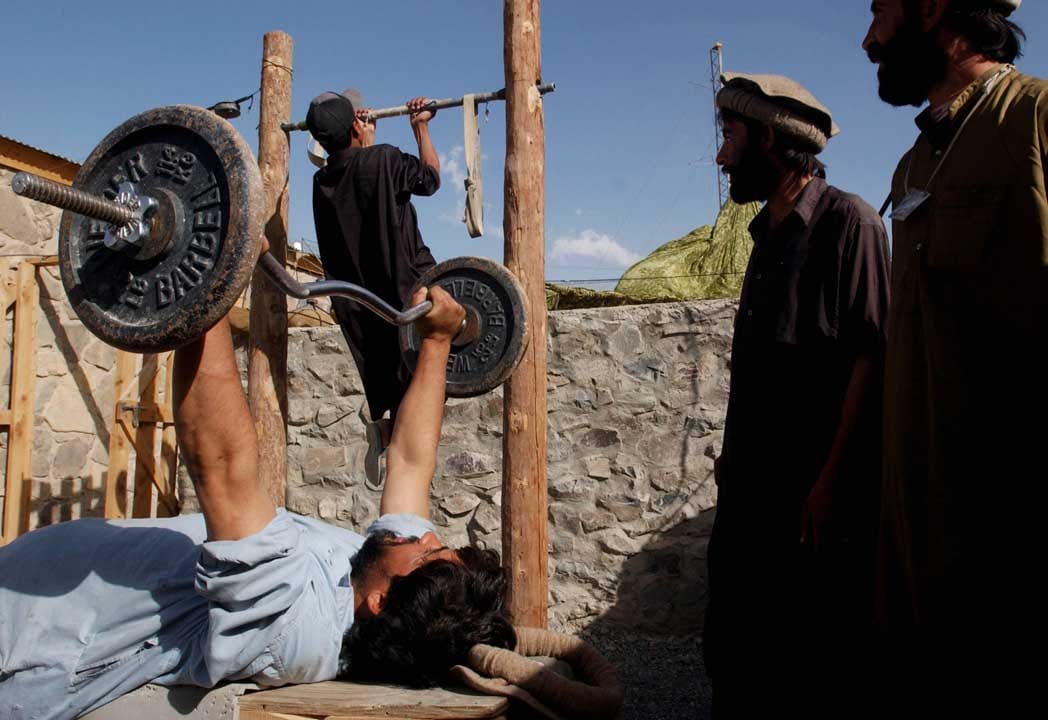 2002年9月15日，阿富汗，幾名阿富汗人在室外的建身設施建身。攝：Chris Hondros/Getty