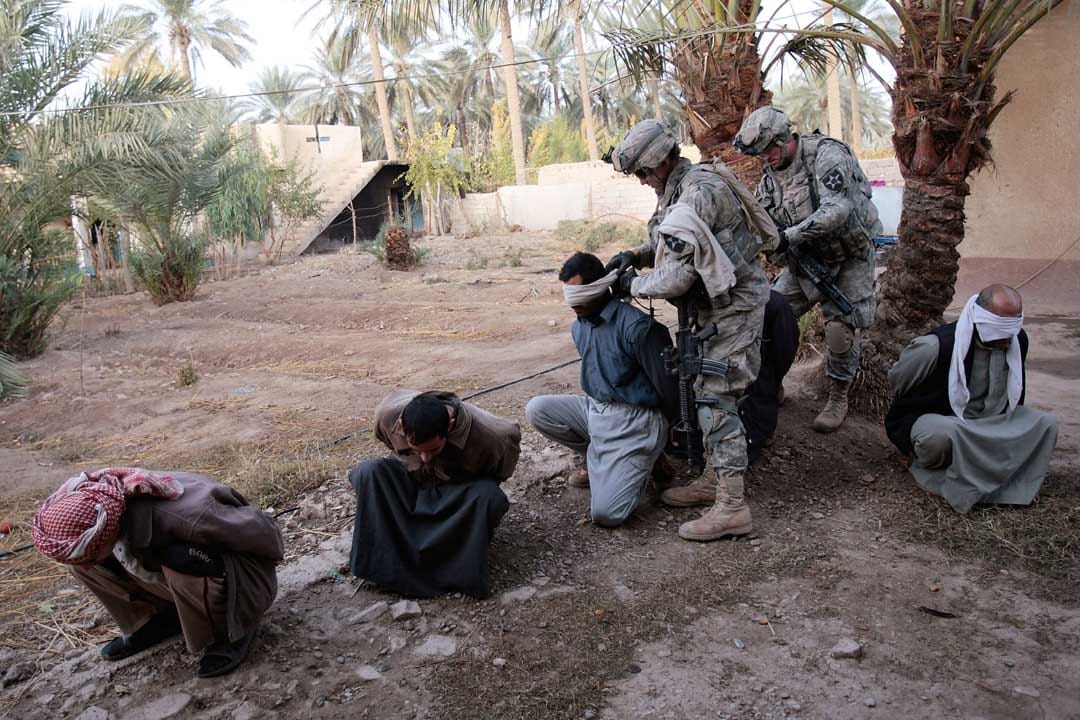 2007年12月3日，伊拉克，被美軍突擊後，數名伊拉克男子被蒙住眼睛。攝：Chris Hondros/Getty