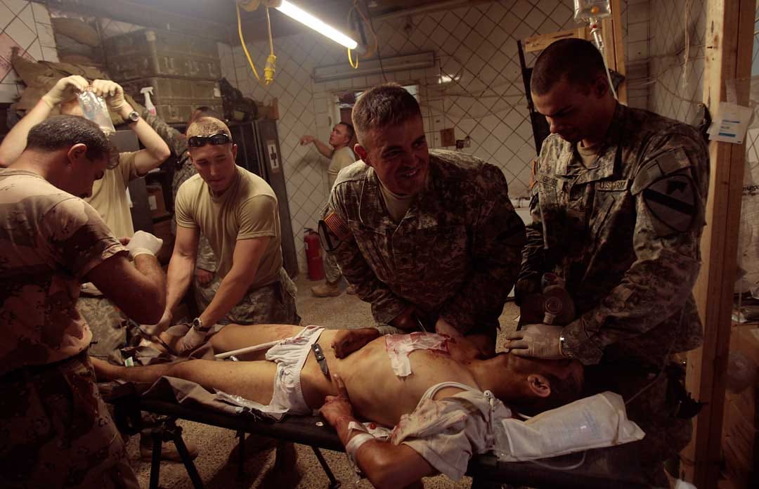 2007年6月29日，伊拉克巴格達，一名陸軍士兵被路邊炸彈炸傷，準備進行胸腔手術。攝：Chris Hondros/Getty