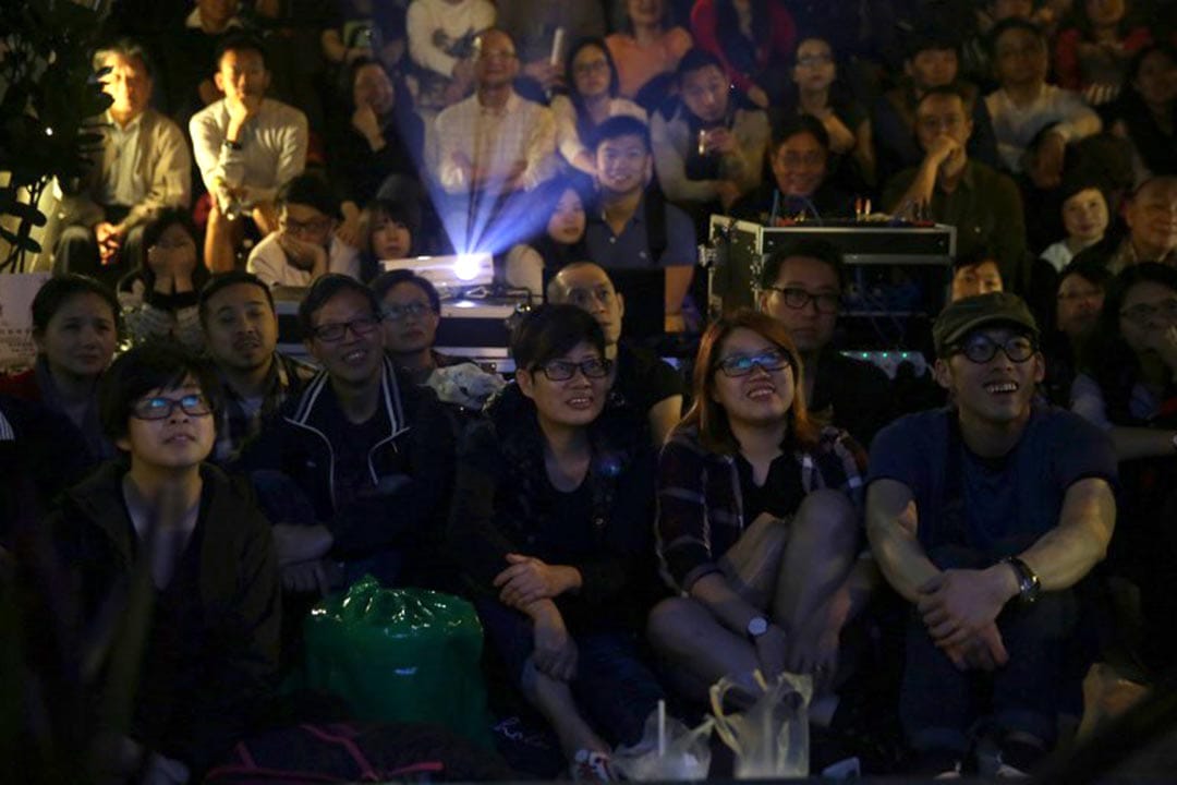 2016年4月1日,《十年》在港九新界多处进行社区同步放映。图为鲗鱼涌市政大厦街市外,市民观看《十年》放映。摄:ISAAC LAWRENCE/AFP