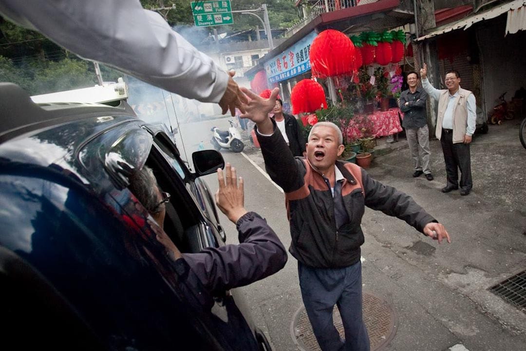 民眾向車上的蔡英文握手。