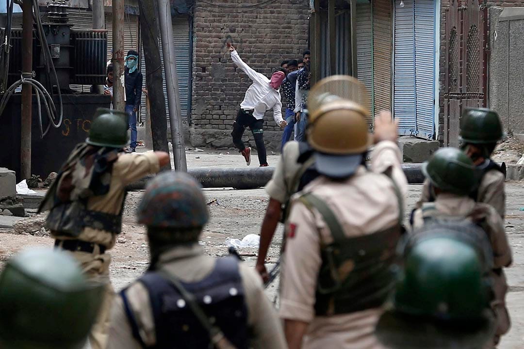 一名穆斯林示威者向印度警察投掷石头。