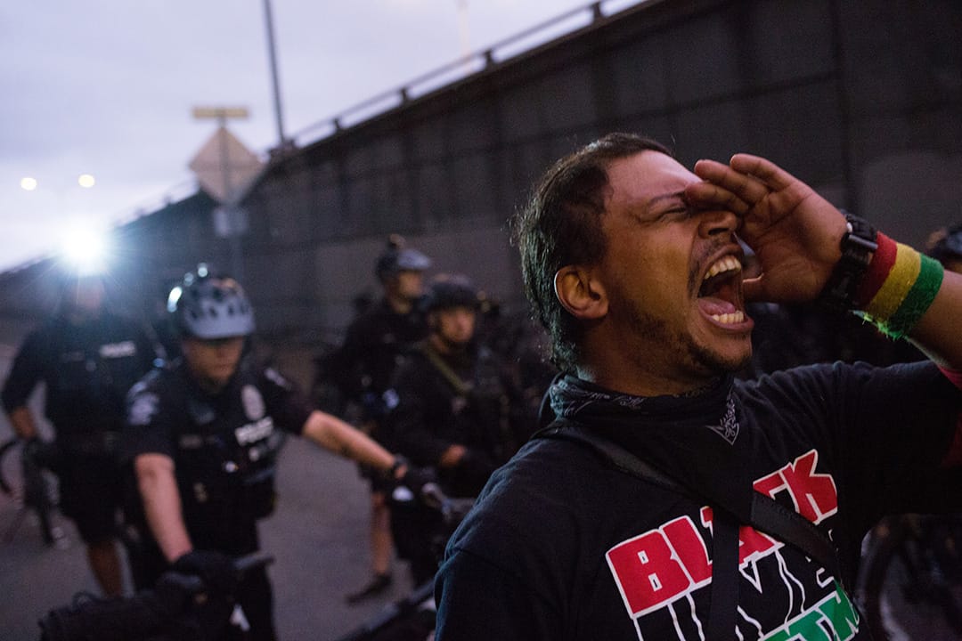 一名示威者在西雅圖示威現場,在警察前面叫喊。