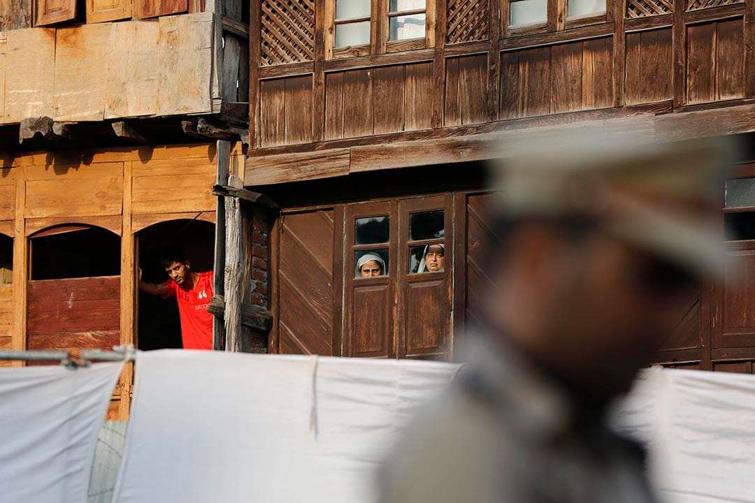 几名喀什米尔市民看着警察祈祷。