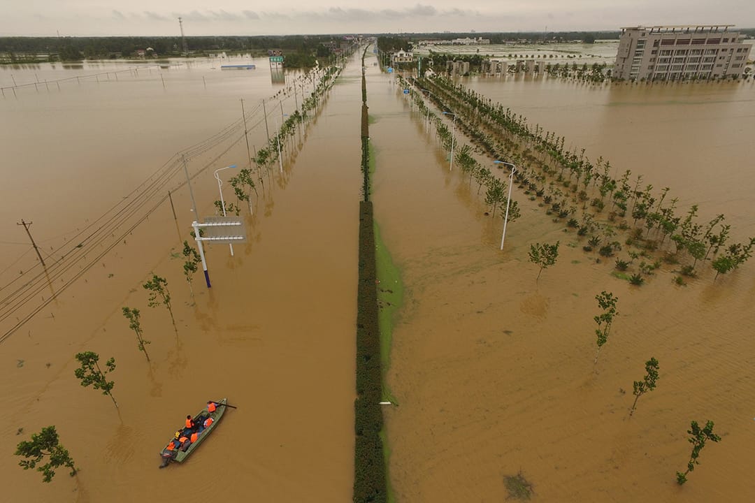 中國安徽，救援人員乘船檢查被洪水淹沒的道路。