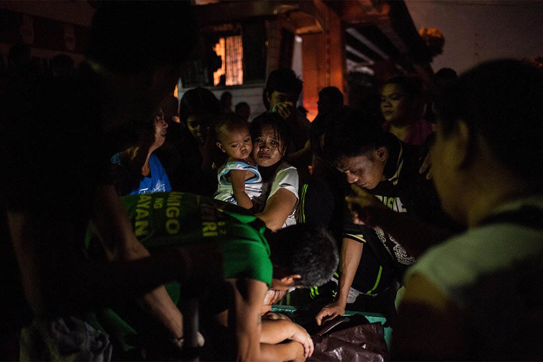 2016年8月17日,菲律宾马尼拉,家属围着一个被疑为毒贩者的尸体。