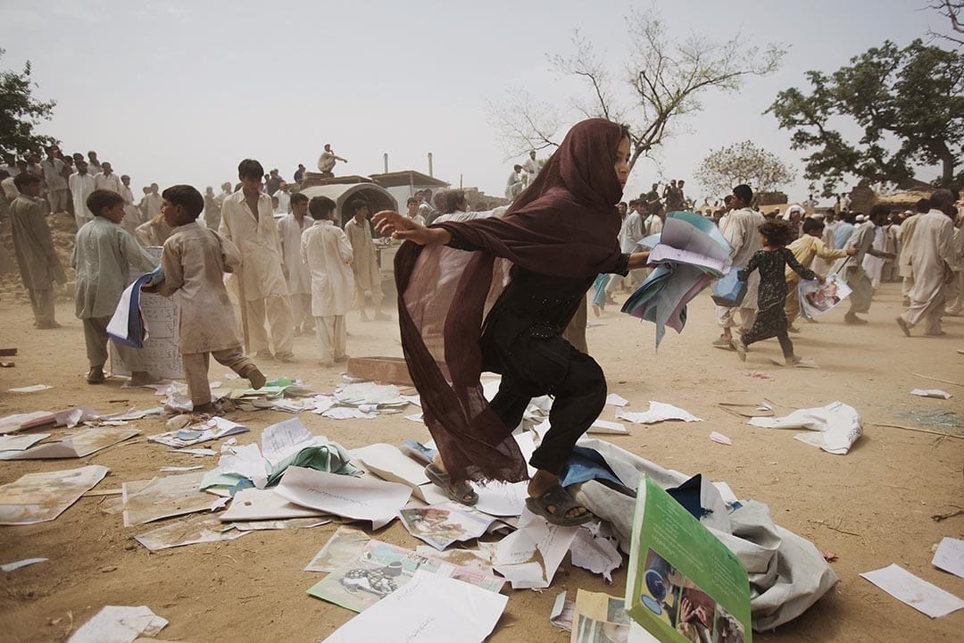 巴基斯坦，暴徒洗劫難民營後，一位流離失所的女孩在逃跑。