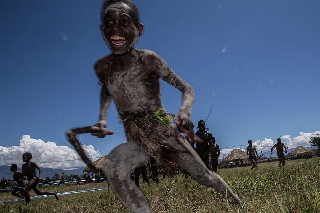 印尼，一個年輕的男孩在巴列姆谷文化節中奔跑著，模擬戰鬥情況。