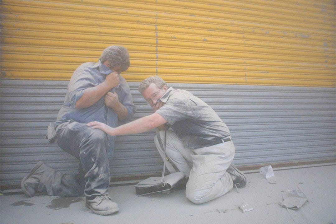 2001年9月11日，世贸中心倒塌后，两名市民在浓烟中掩著面。