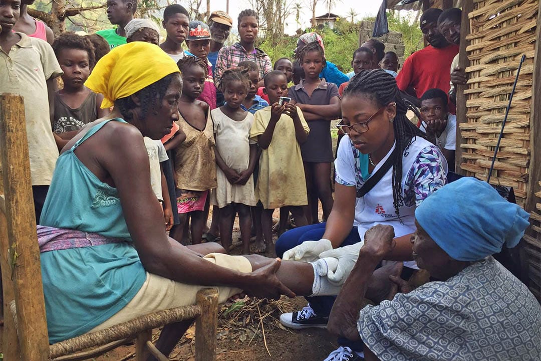 一名来自海地的无国界医生护士乘坐直升机到皮茫港北面山区的一条村落为村民治理伤口。
