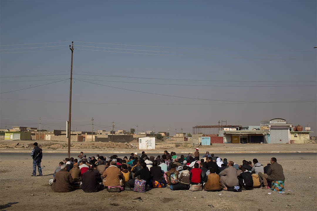 2016年11月7日,伊拉克高吉亞利,一群男士等待車輛前往國內流離失所者營地。