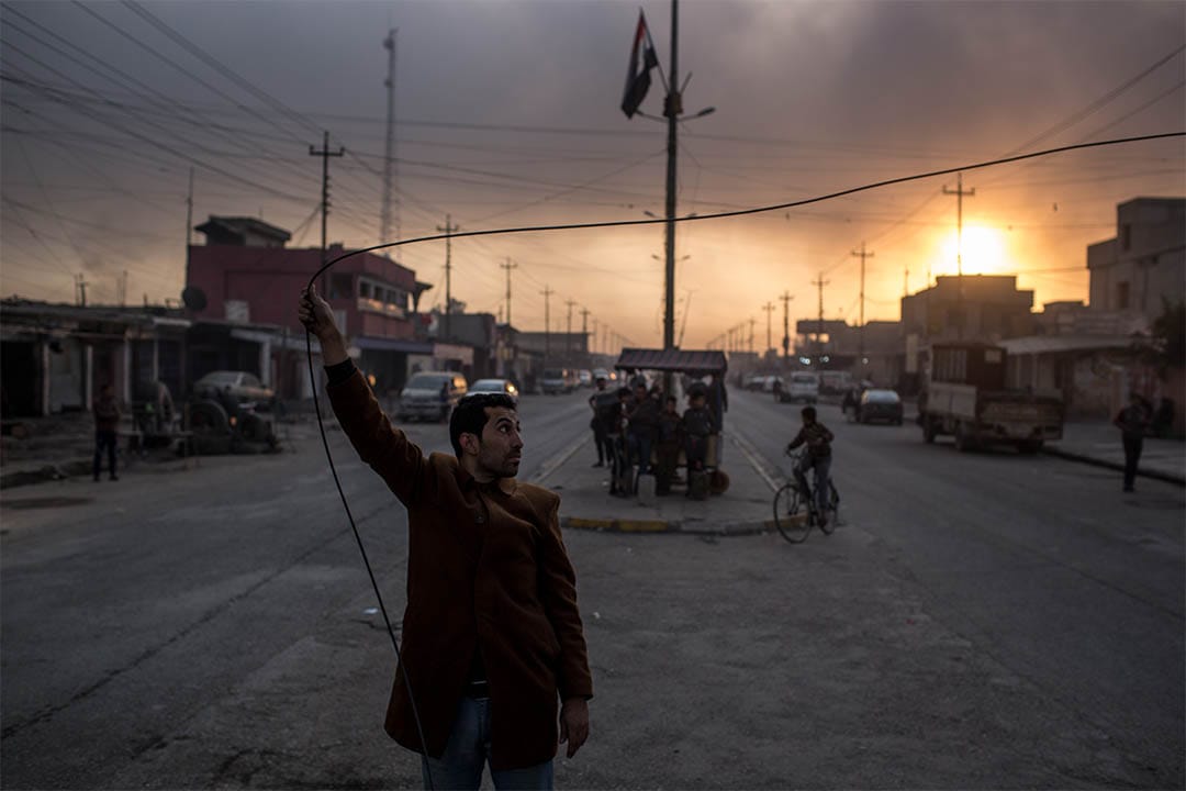 2016年11月9日,伊拉克蓋亞拉,一個男人手抓住電纜。