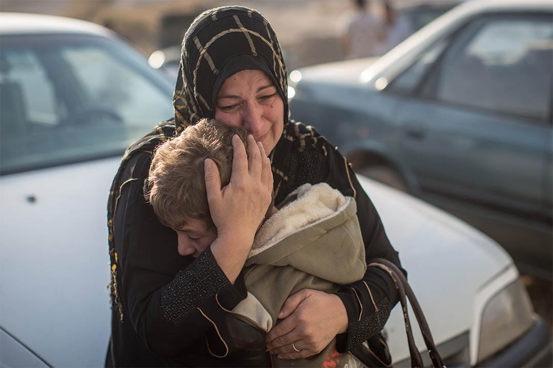 2016年11月7日,伊拉克高吉亞利,一個女人回到家鄉後緊抱著分隔兩年多的孩子。