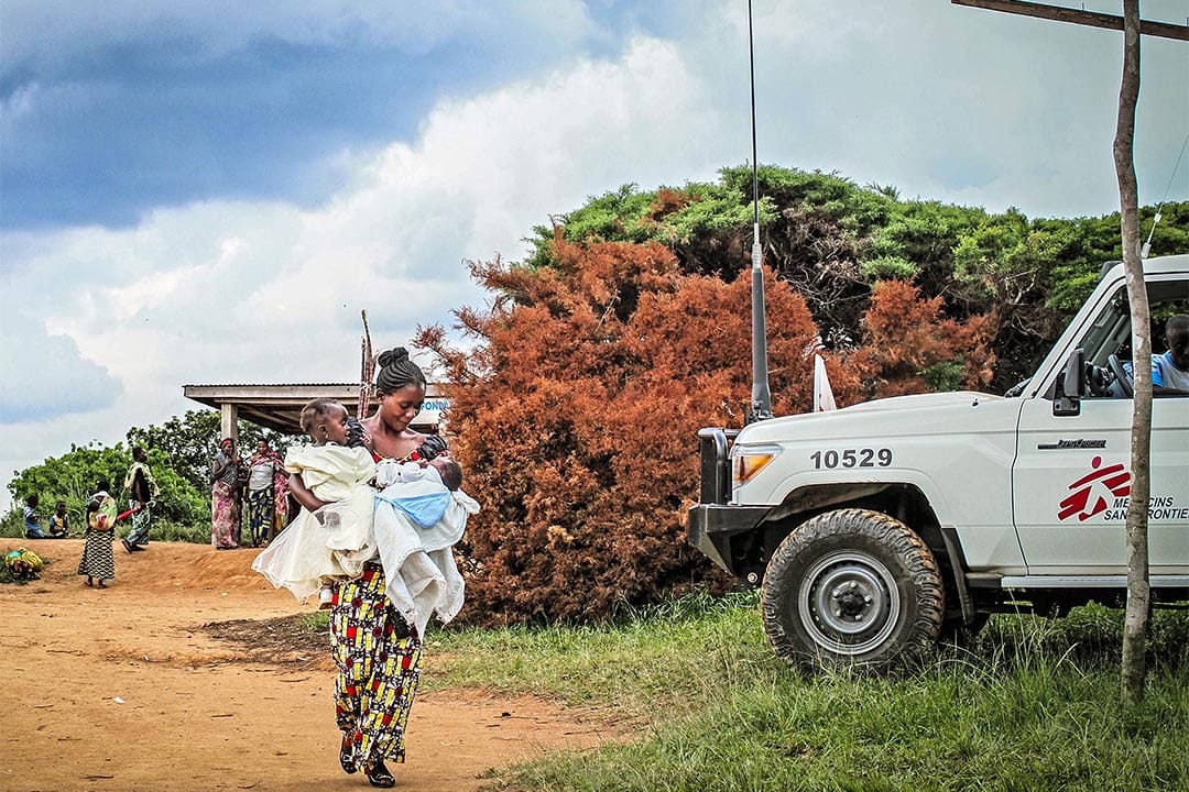 2015年10月，剛果民主共和國博加(Boga, Democratic Republic of Congo)，無國界醫生在進行社區健康護理及健康推廣計劃，一名母親抱著她的兩個孩子到健康中心，接受小兒麻痺疫苗注射。