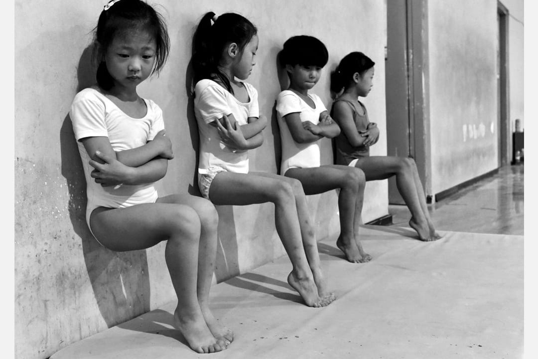 在中國徐州一所體操學校內，四名體操學生正在做腳趾壓力訓練。