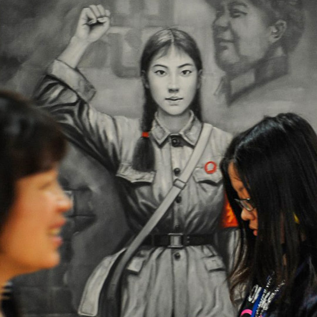 過去於上海舉辦的一個藝術展覽內,一幅文化大革命時期的紅衛兵畫像前,一名年青女孩和一名婦女迎面走過。