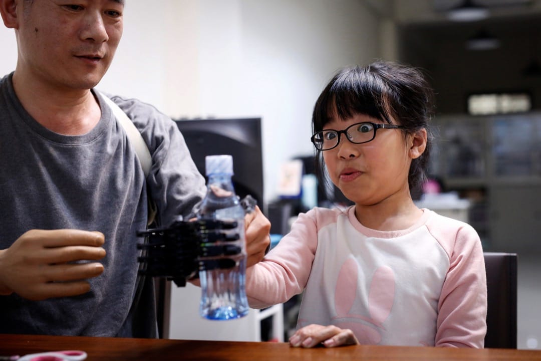 戴上義肢的Angel嘗試拿起水樽。