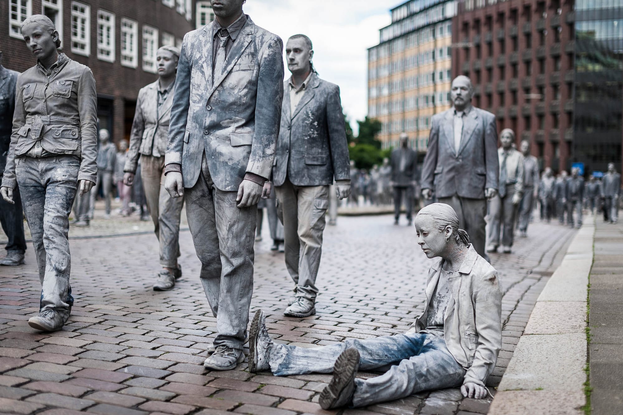 2017年7月5日,「1000 Figures」的行為藝術表演中,這位表演者頹喪無力地坐在路邊,目光空洞。