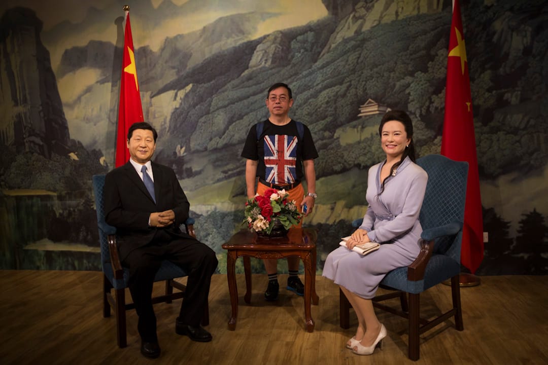 2017年7月1日,香港回歸20年之際,香港杜莎夫人蠟像館中,一位身穿印有英國國旗的T恤的市民和國家主席習近平及其夫人彭麗媛的蠟像合影。