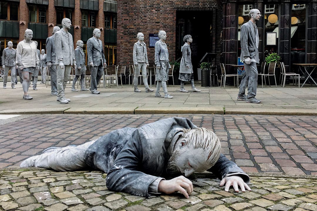 在「1000 Figures」的行為藝術表演中,有參與者穿著皮衣躺在街頭上,表達出在現今政經環境異常複雜的世界裡,社會大眾常有的一種無力感。