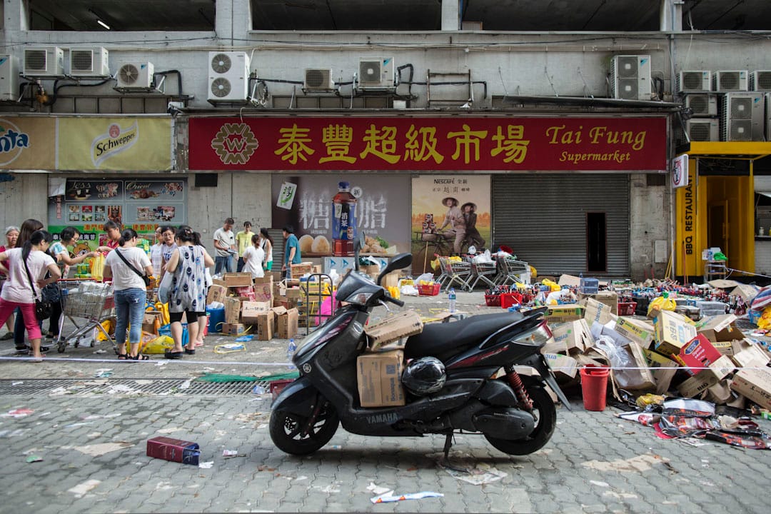 超市因斷水電不能開門，市民要到超市門外戶外買必需品。