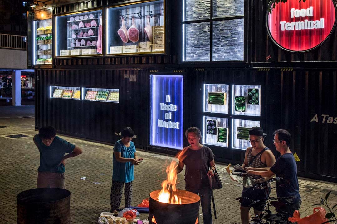農曆七月十四前夕,居民於啟業邨街市外燒街衣,剛裝修的街市,以貨櫃箱的形式設計大門。該區為舊 式公共屋邨,住了不少基層長者。