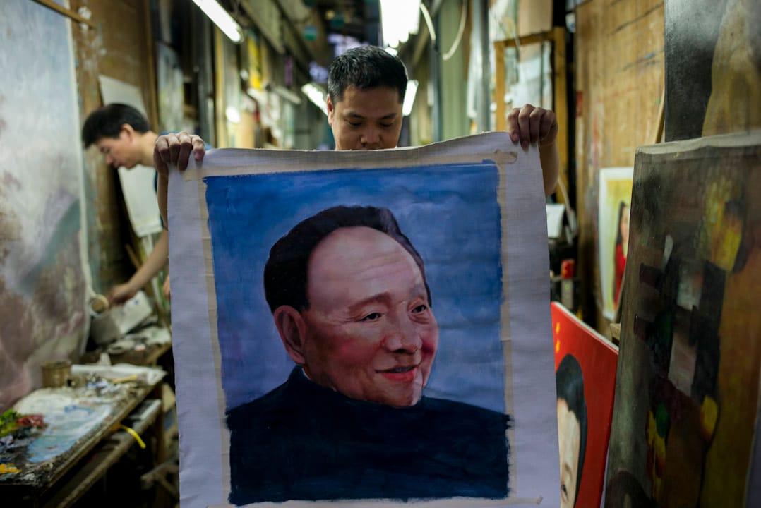 大芬村一條巷子裏,一個畫家正在展示他正在打草稿的鄧小平肖像。