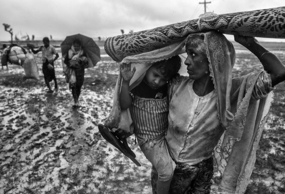 2017年9月28日，一名羅興亞難民婦人抱著孩子從納夫河徒步到臨時難民營。