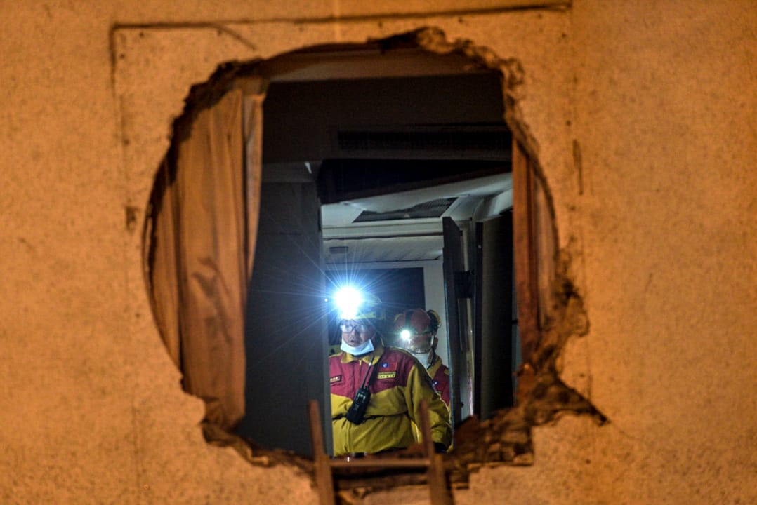 凌晨三時,消防員在災情嚴重的統帥大飯店現場搜索生還者。