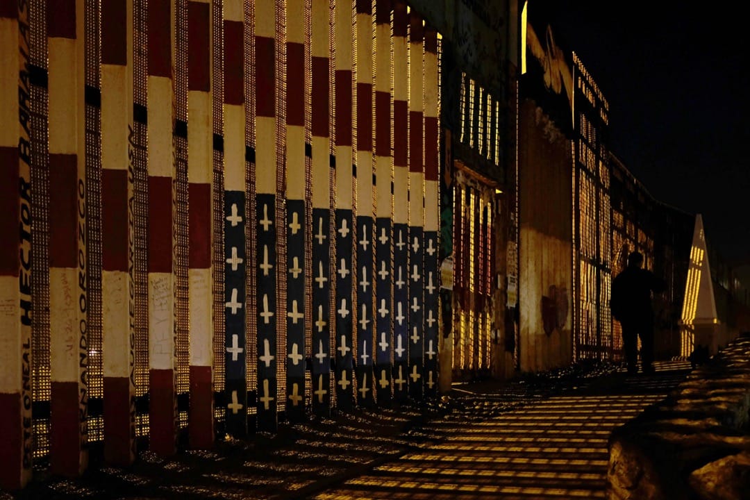 2018年4月5日,墨西哥蒂華納,一名墨西哥人在墨美邊境圍欄旁走過。