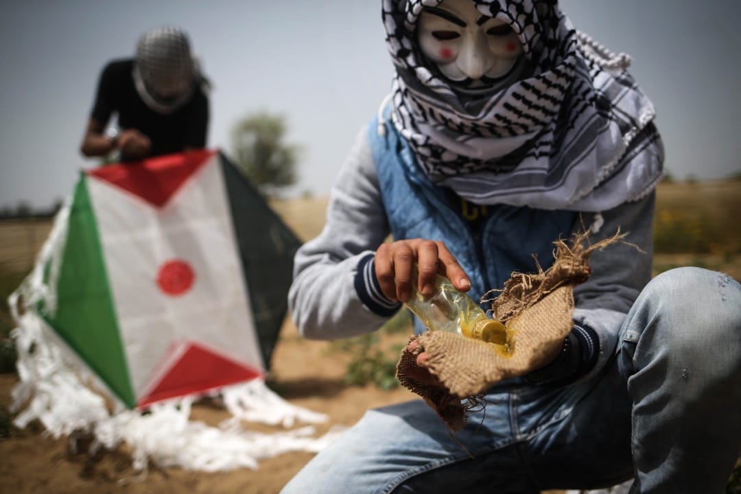 2018年4月20日,加沙地區,兩名巴勒斯坦示威者整準備用風箏將土製燃燒彈飛越以色列邊防部隊投擲到以色列領土上。由巴勒斯坦人發起,計劃持續至5月15日的「回歸大遊行(The Great March of Return)」步入第四週,巴勒斯坦示威者不斷用創新的方式攻擊以方邊防部隊。