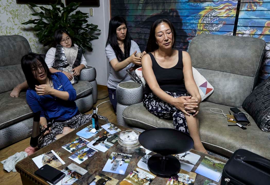 韩国堤川市,萨满法师Cheonsindangju闭著眼享受弟子为她梳头。