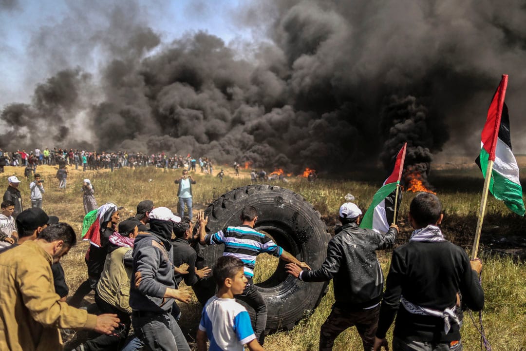 示威者準備焚燒車胎製造黑煙遮擋以色列狙擊手的視線。