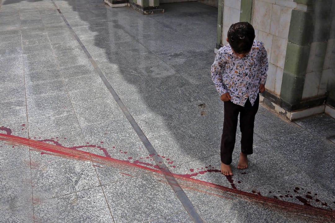 2018年5月14日,也門城市塔伊茲,一名男孩凝望著地上的血痕。較早前市內最大的清真寺的領袖 Mohammed Al-Zabhani被刺殺,在地上留下血跡。