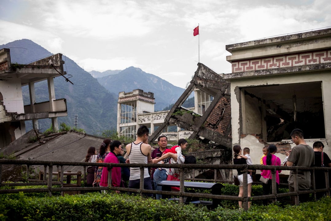 映秀地震遗址的漩口中学前,一群游客正在游览。