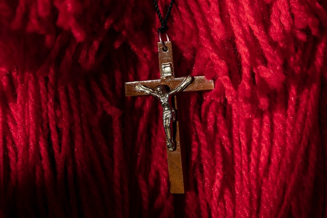 一名身穿传统服饰的舞蹈员穿戴耶稣钉十字架的饰物。