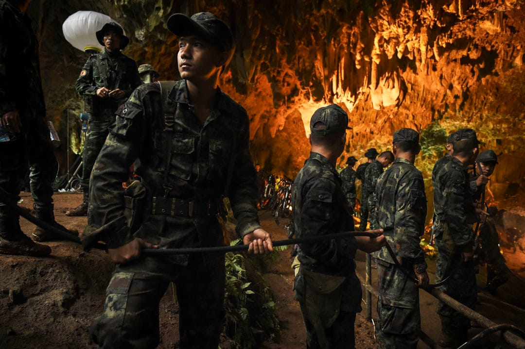 6月26日，泰國軍隊士兵正把電線拉進洞穴內，方便搜救工作進行。