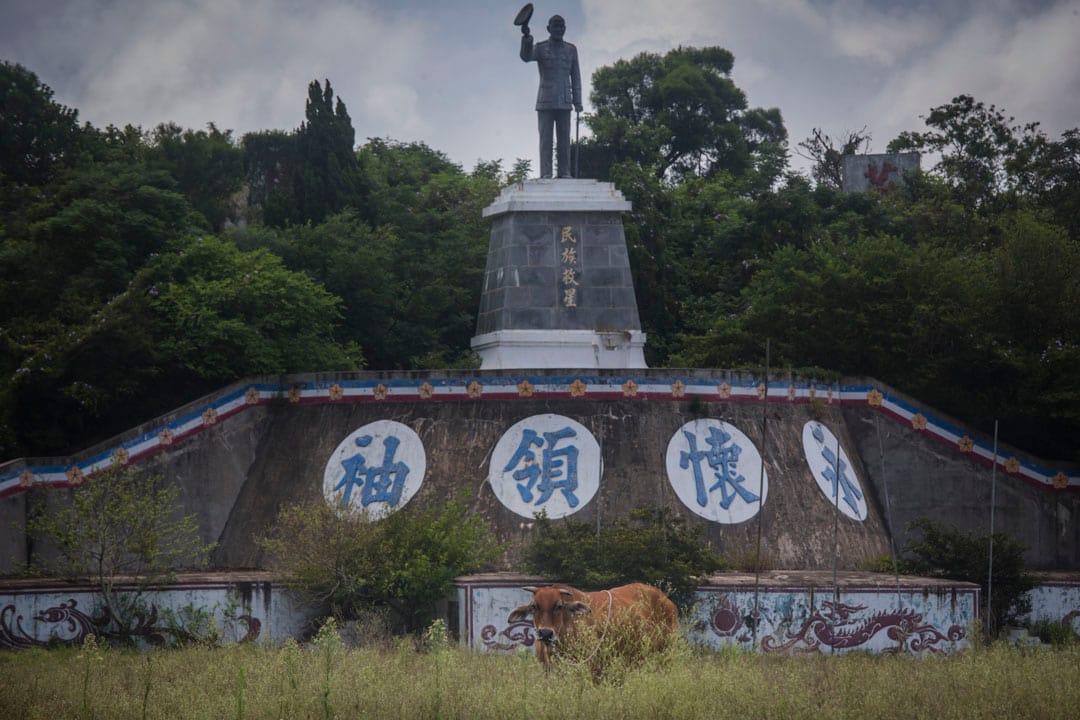 小金門島上豎立了一個蔣介石像，空地被野草和牛佔據。