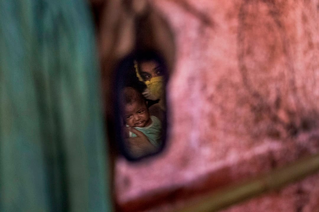 从一面镜中可见到“M”抱著男婴。