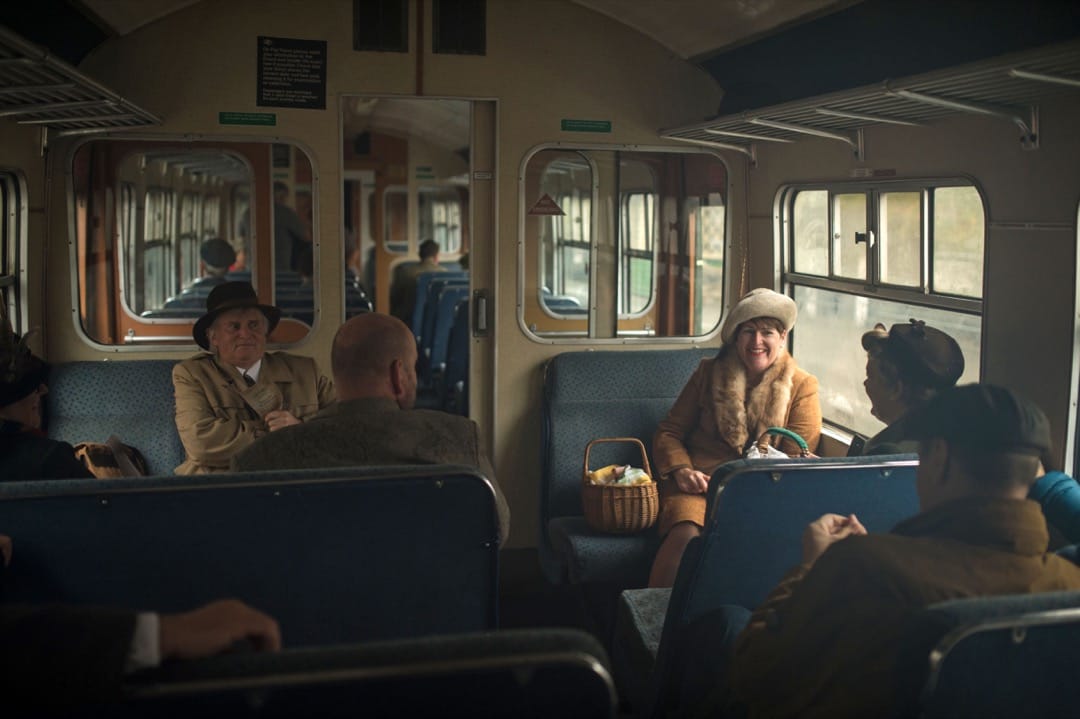 数名乘客在车厢内谈天，正享受这趟旅程。