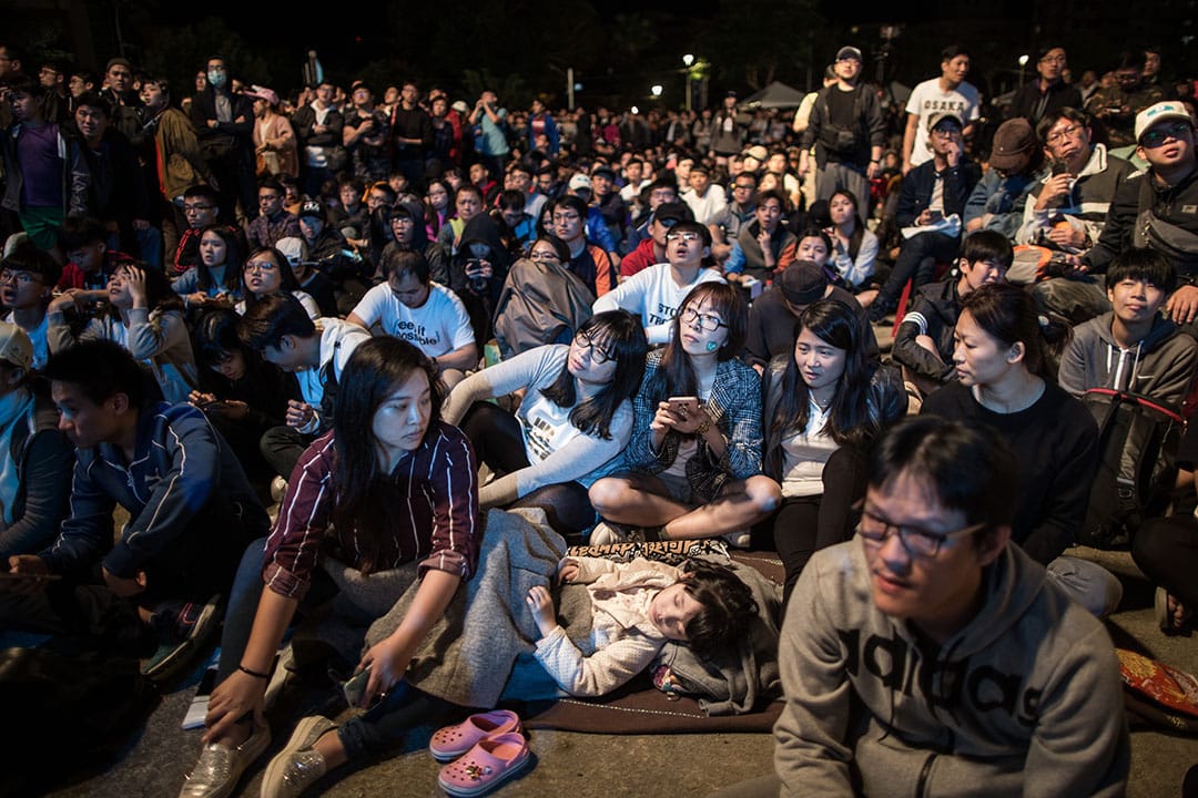 這場選舉打破多項台北市選戰紀錄,特別是開票一路從下午四點進行到隔天凌晨,過程中柯文哲與丁守中票數一路拉鋸,直到隔夜的凌晨兩點三十七分開票才暫告一段落。 圖為等待結果的柯文哲支持者。