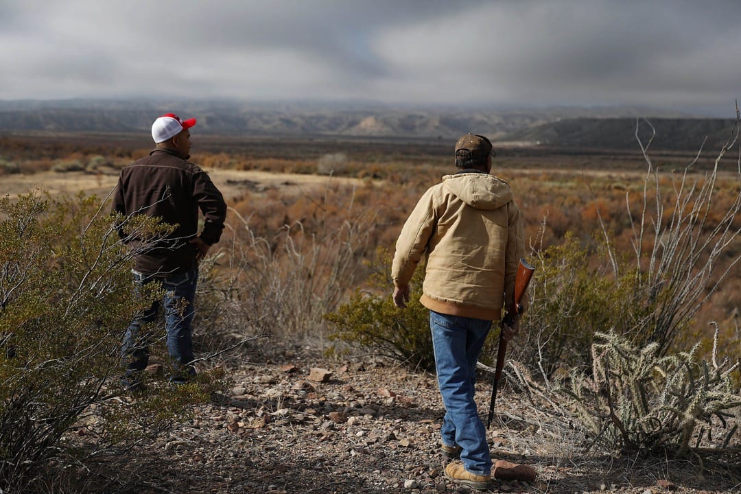 美國德州,Adan Madrid 父子在他們位於坎德拉里亞市的馬場遠觀美墨邊境。