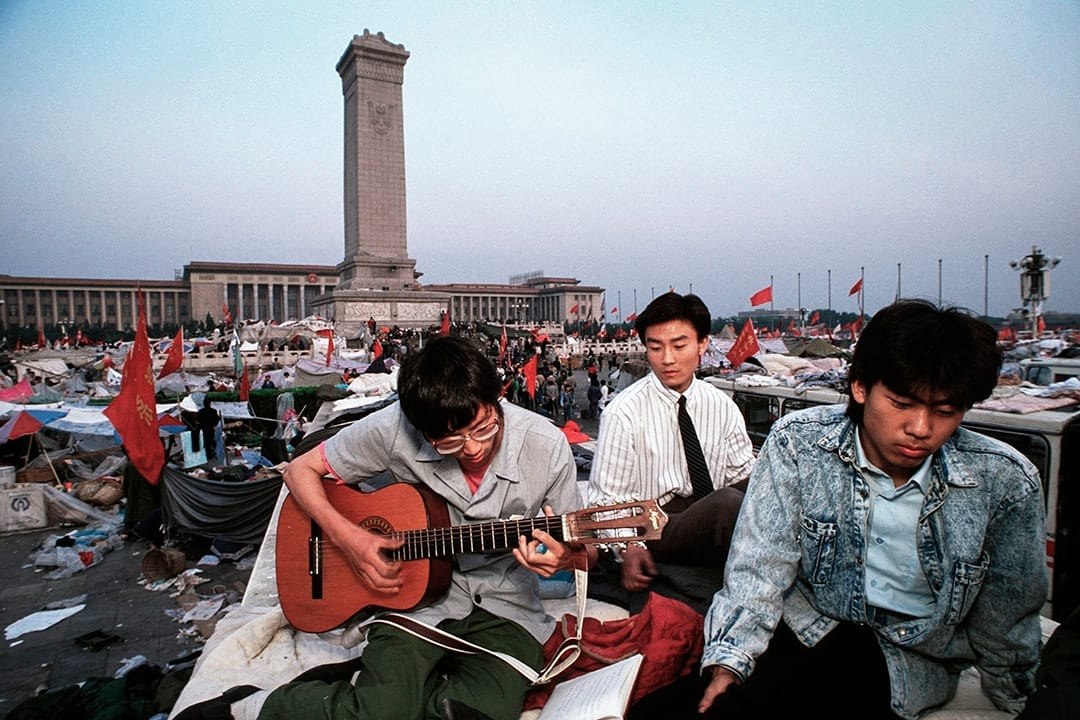 1989年6月1日,北京留守天安门的示威学生在广场弹吉他。