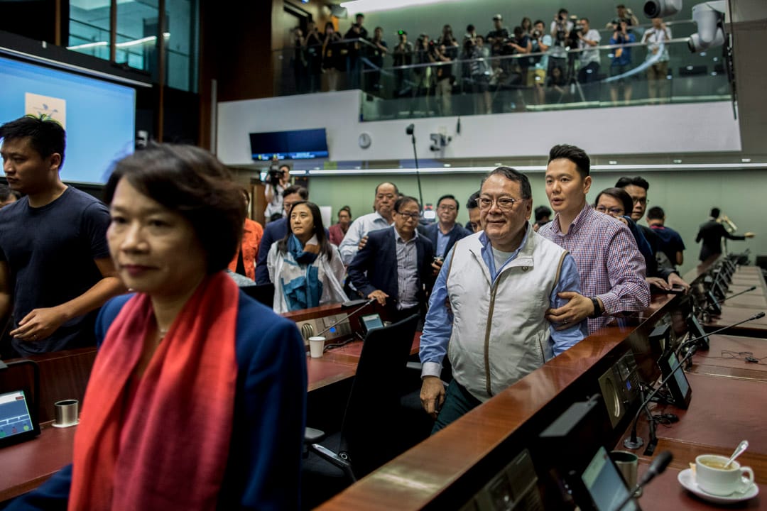 12:02PM - 經民聯議員石禮謙在數名建制派議員護送下離開會議室。