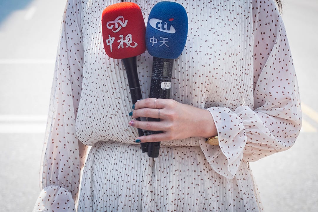 一名記者拿著中天電視的咪高峰。
