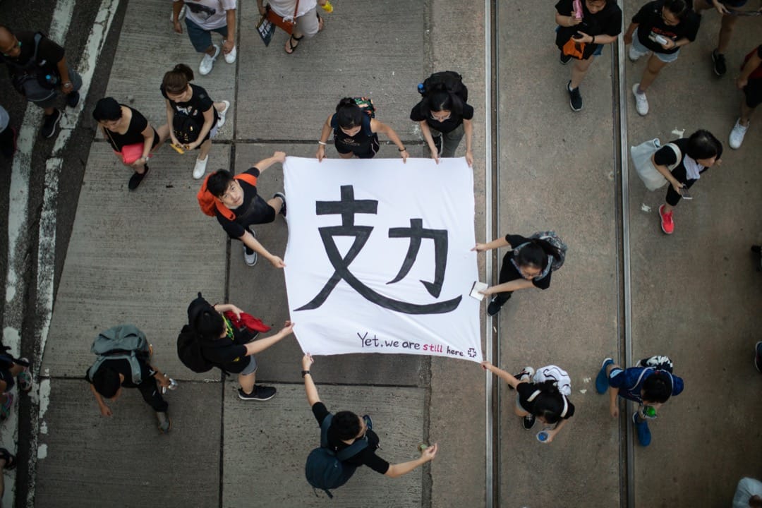 2019年7月1日，民陣發起七一大遊行，有參加者拿著寫有「攰」字的橫幅。