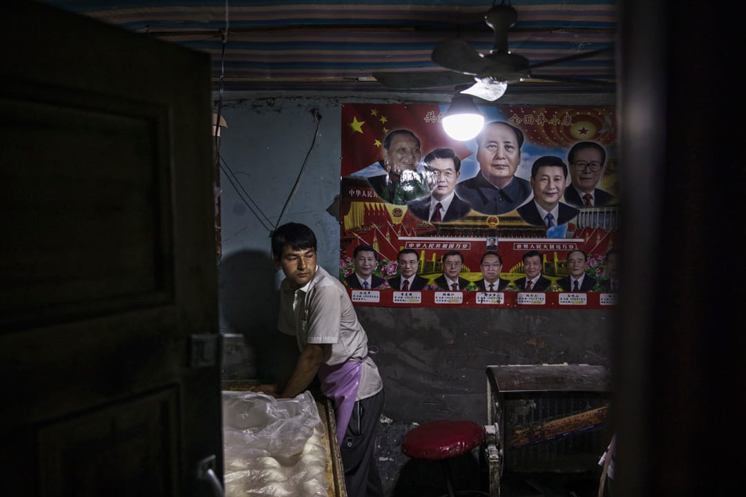 2017年7月1日,中国新疆西部喀什老城区的一家馕店,店后方有一张历任中共领导人的海报贴在墙上。