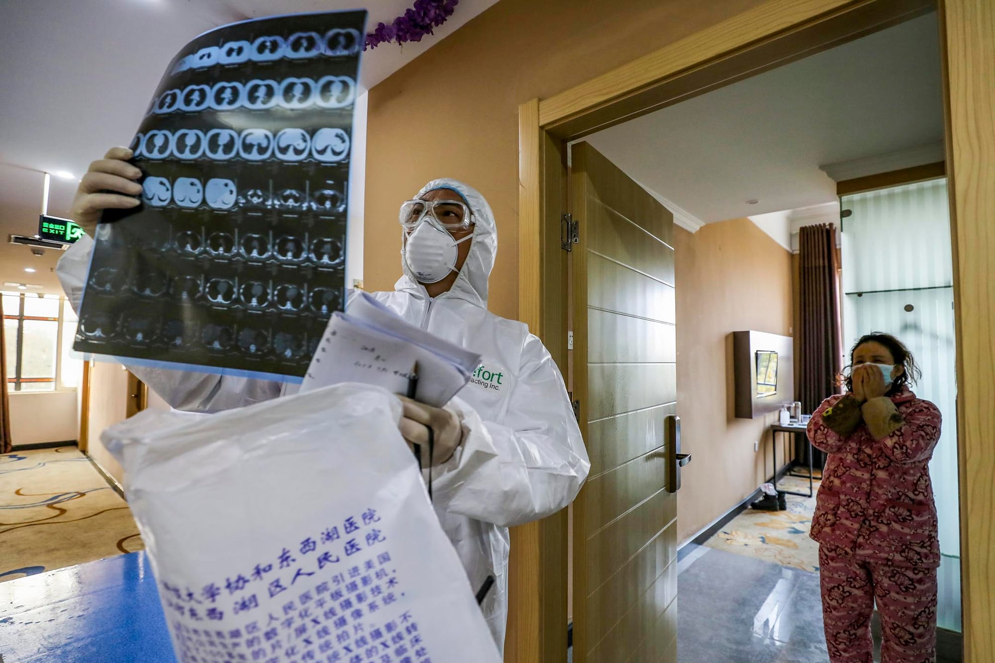 2020年2月3日,武漢市隔離區的一間病房裡,醫護人員巡視病房並查看隔離人士的肺部CT圖像。