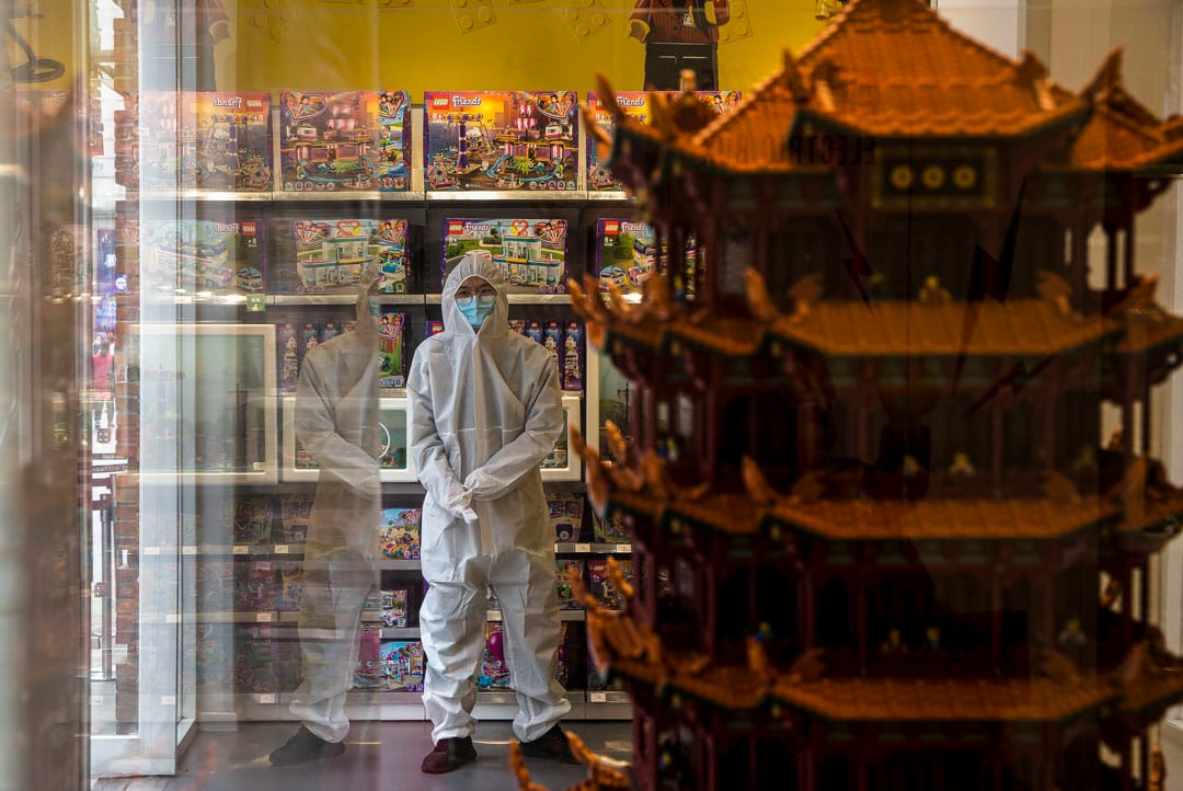 武漢漢街，店員穿防護服守在門口，等著為進門的顧客測量體溫。 